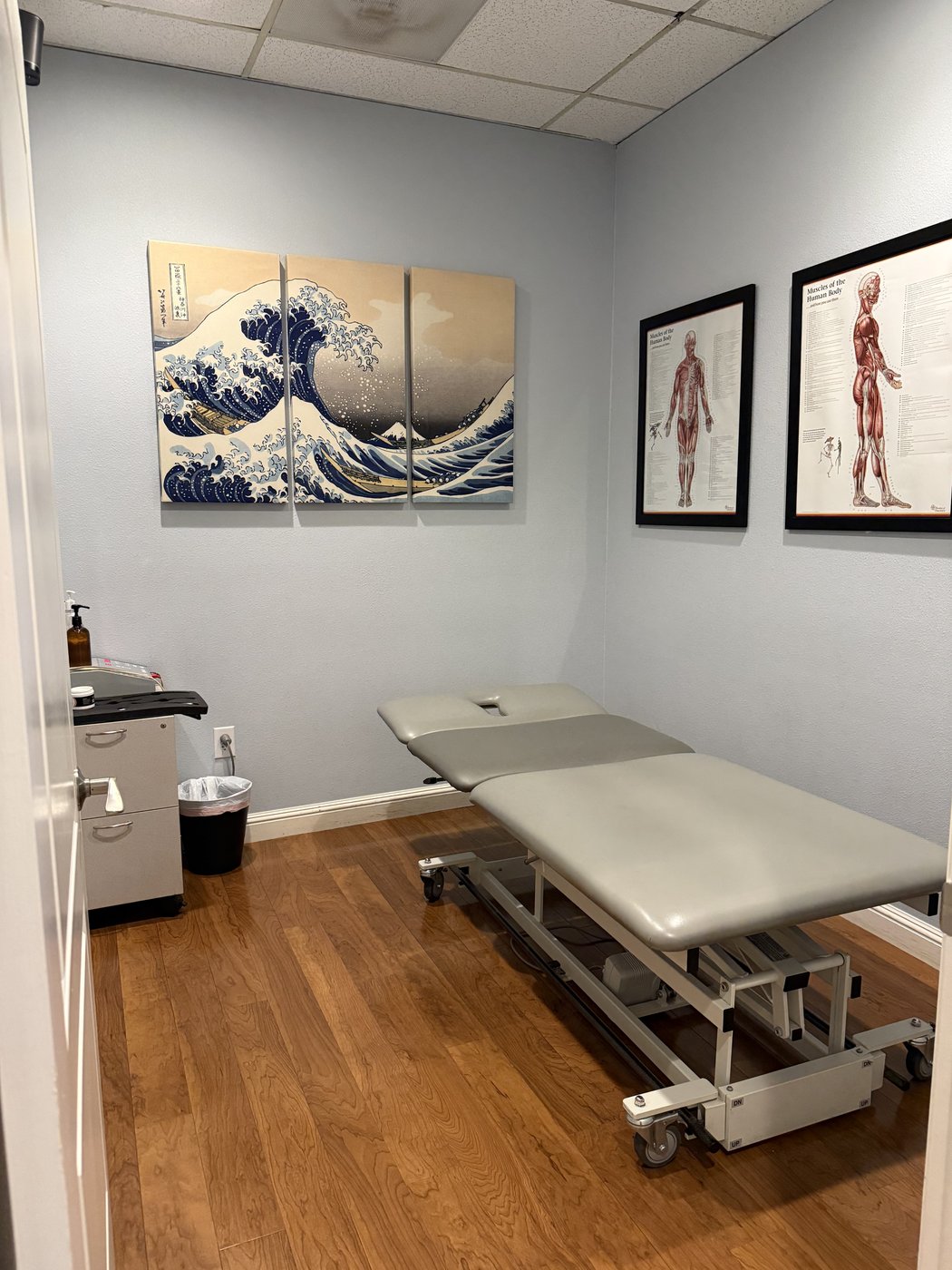 VAL Chiropractic treatment room with chiropractic table and The Great Wave artwork